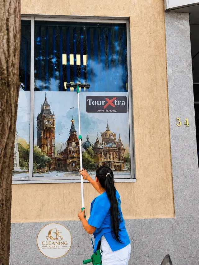 Curățarea unui geam din exterior, cu unelte cu prelungitor.